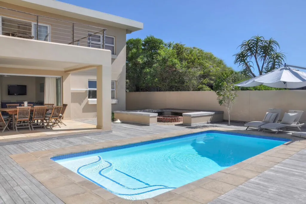 Modern house with a swimming pool lounge chairs and outdoor dining area