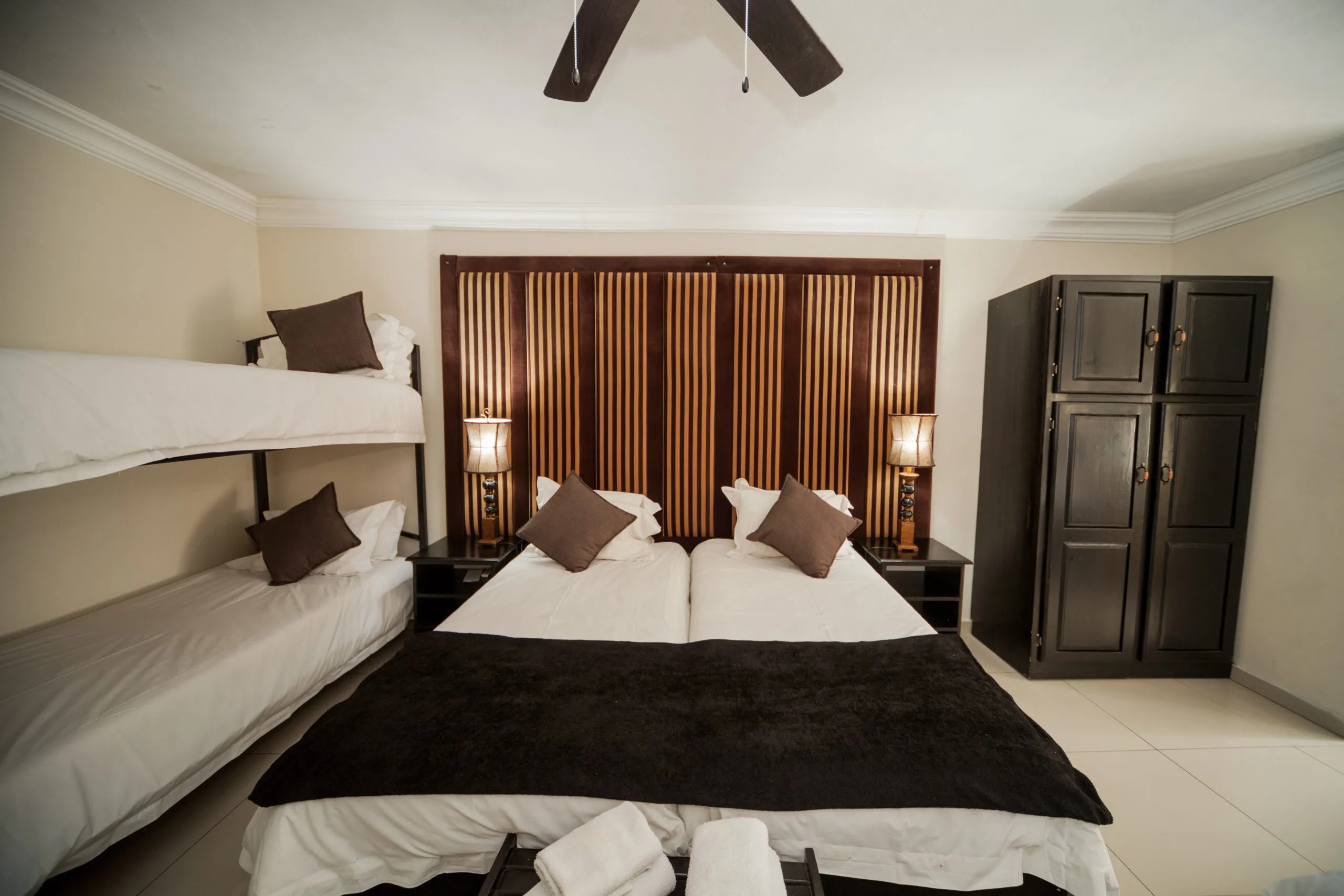 Bedroom with double bed bunk bed wooden headboard and ceiling fan