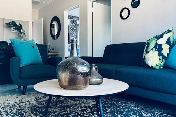 Modern living room with blue furniture decorative vases and floral pillows