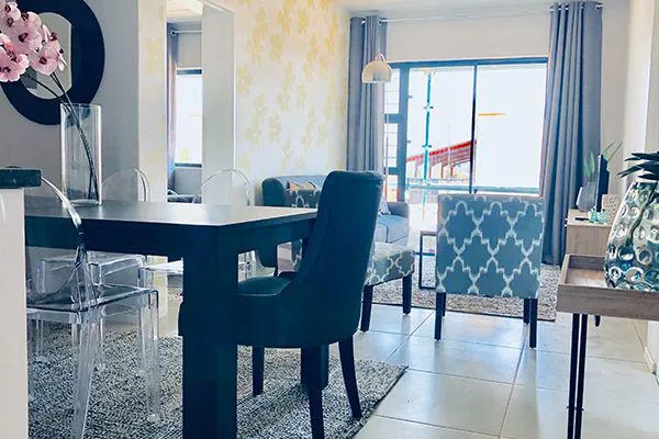 Modern dining area with table chairs and view of living room and patio