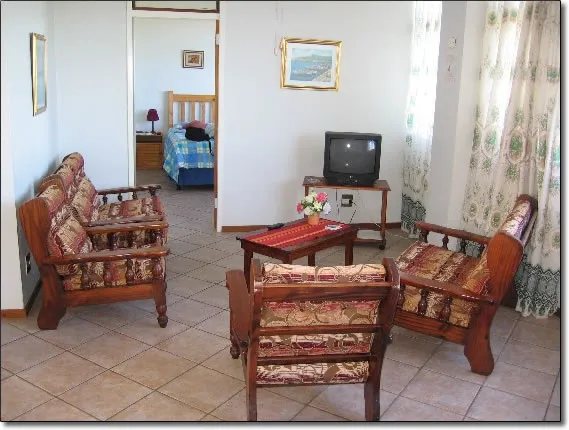 Cozy living room with floral furniture TV and view into a bedroom