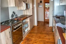 Modern kitchen with wooden floors stainless steel appliances and open doorway