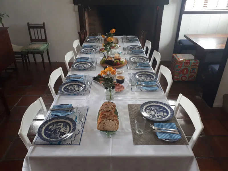 Dining table set with plates bread flowers and glasses in a cozy room