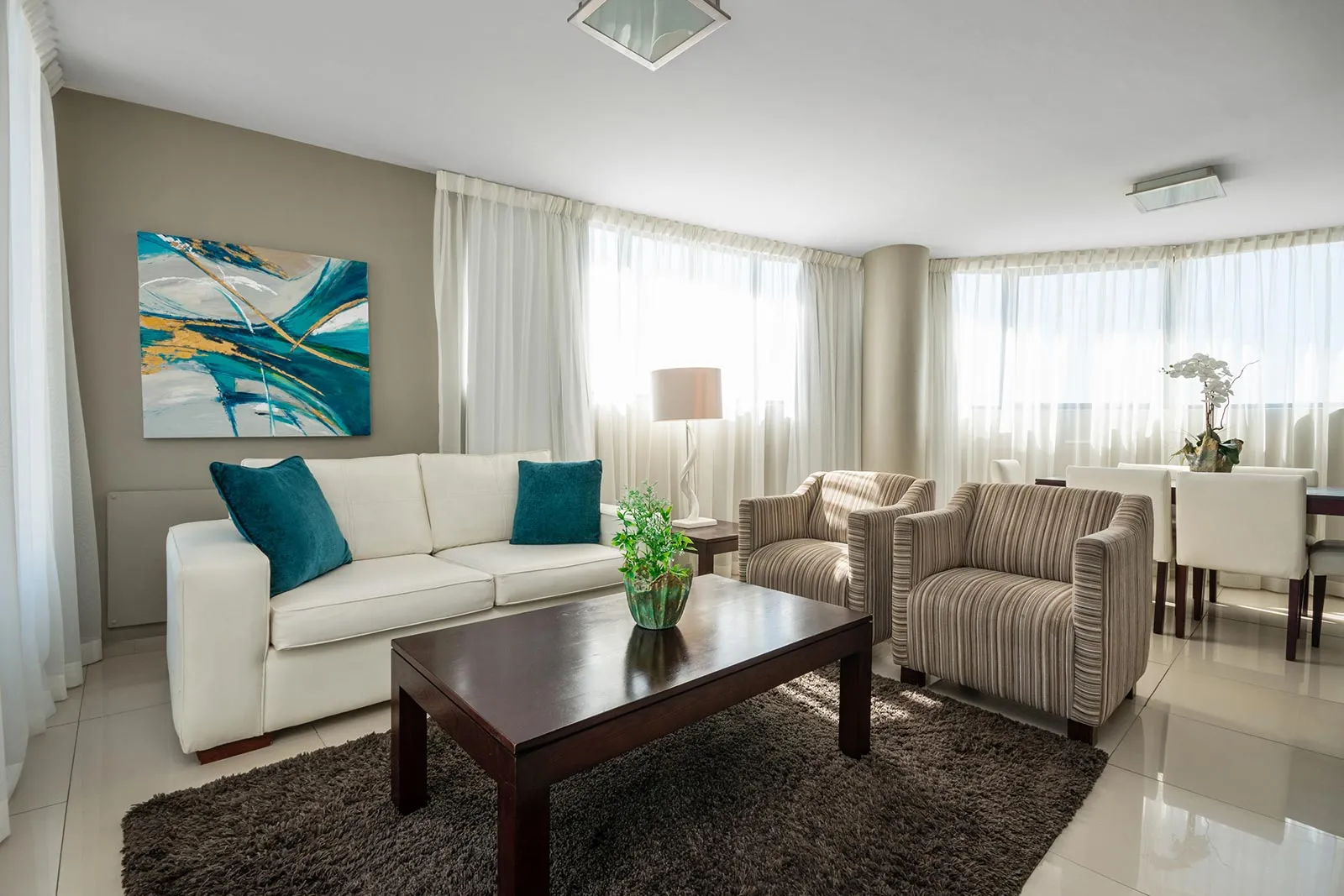 Modern living room with sofa armchairs coffee table and large windows