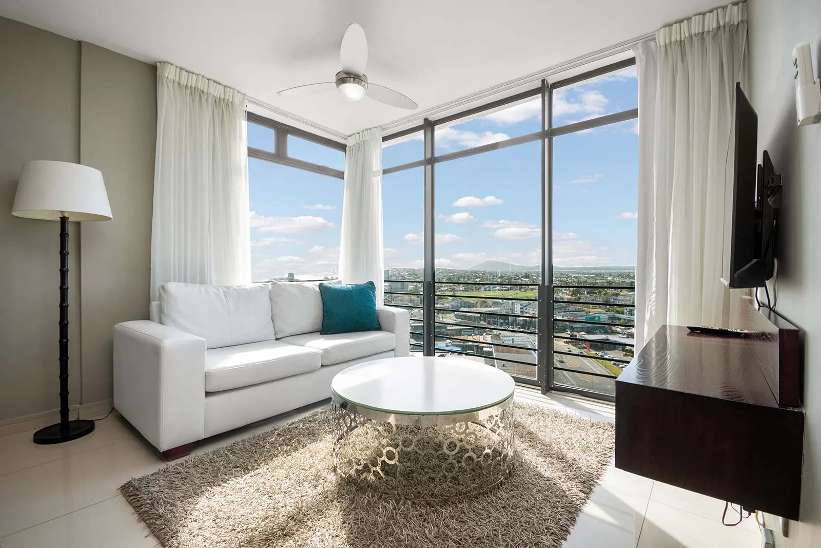 Modern living room with large windows white sofa and city view