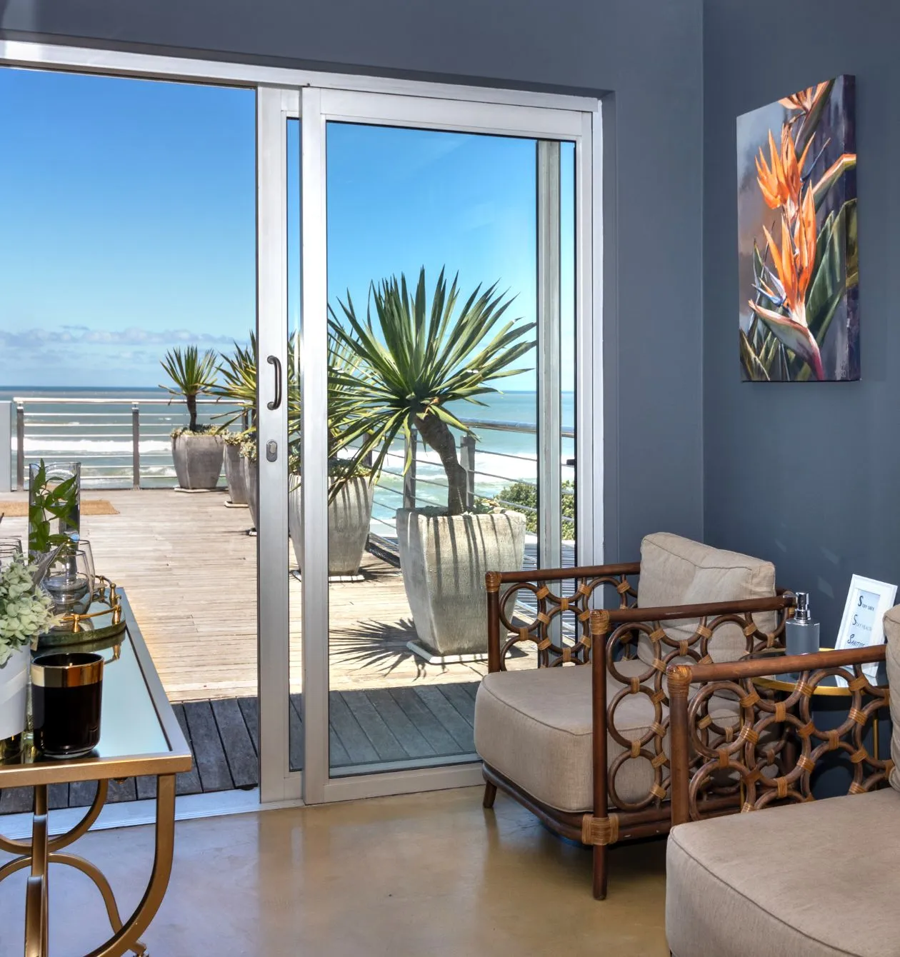 Modern room with sliding glass door to deck ocean view and wicker chairs