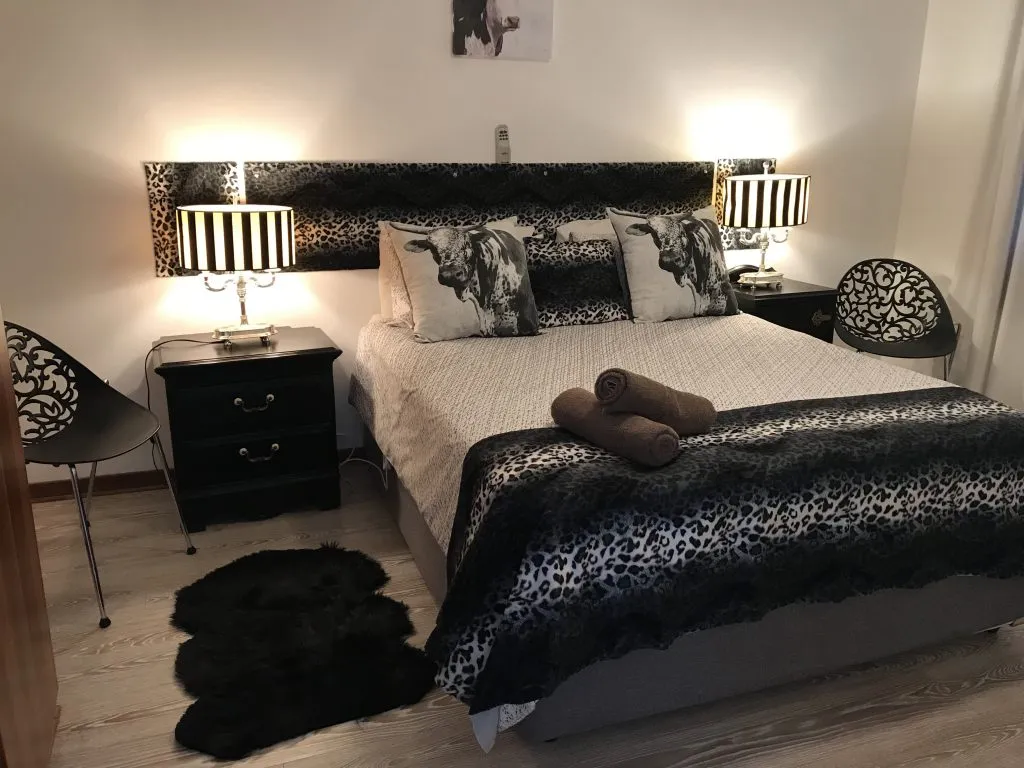 Bedroom with black and white decor two bedside tables and two chairs