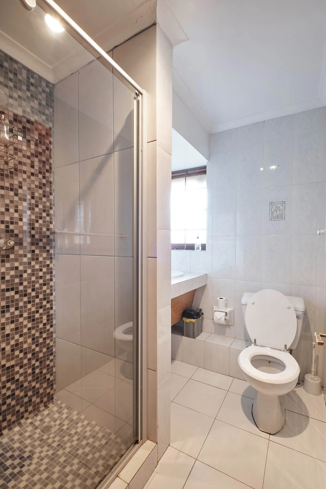 Modern bathroom with shower toilet and tiled walls and floor