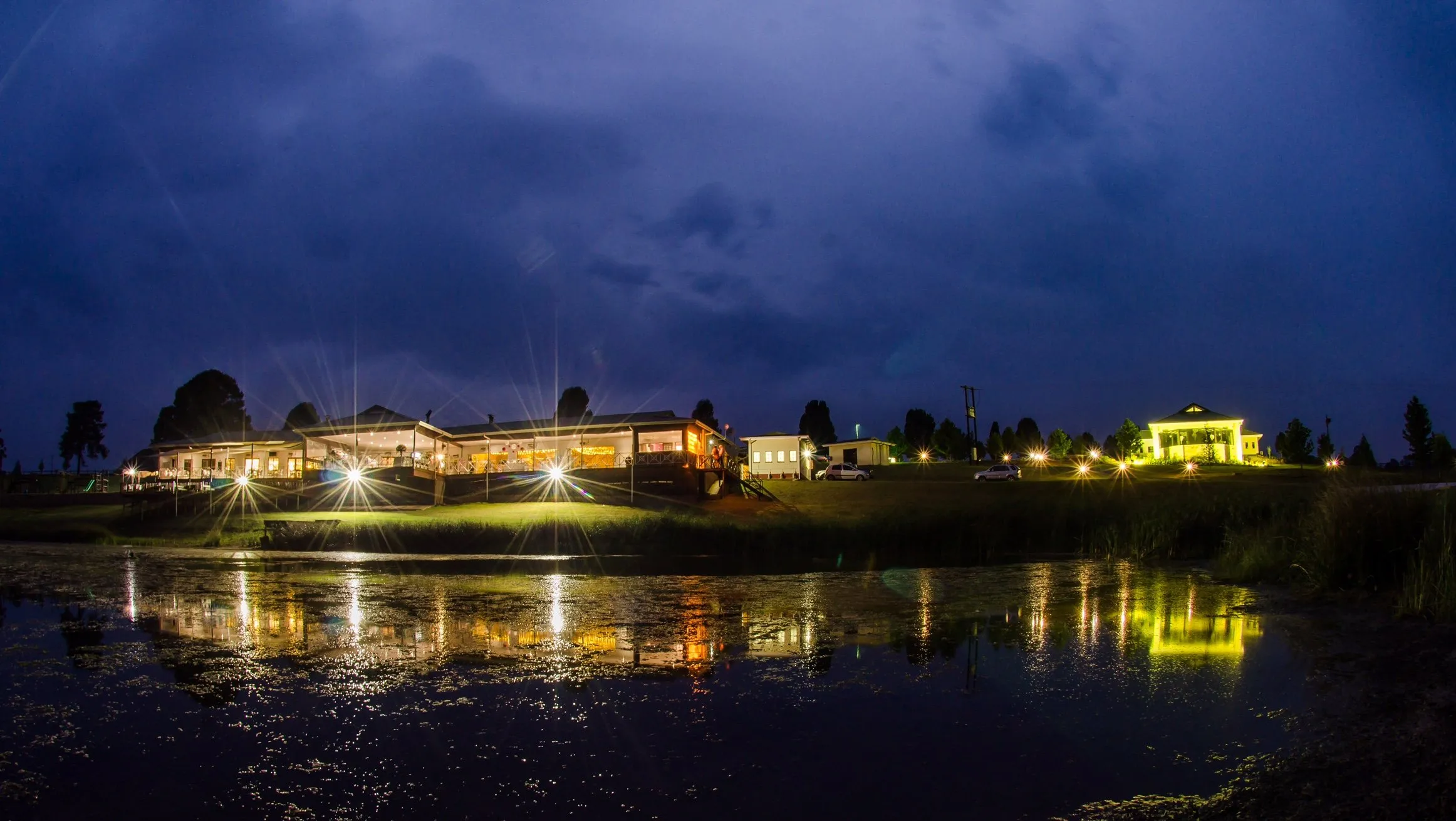 Night view of illuminated buildings by a reflective body of water