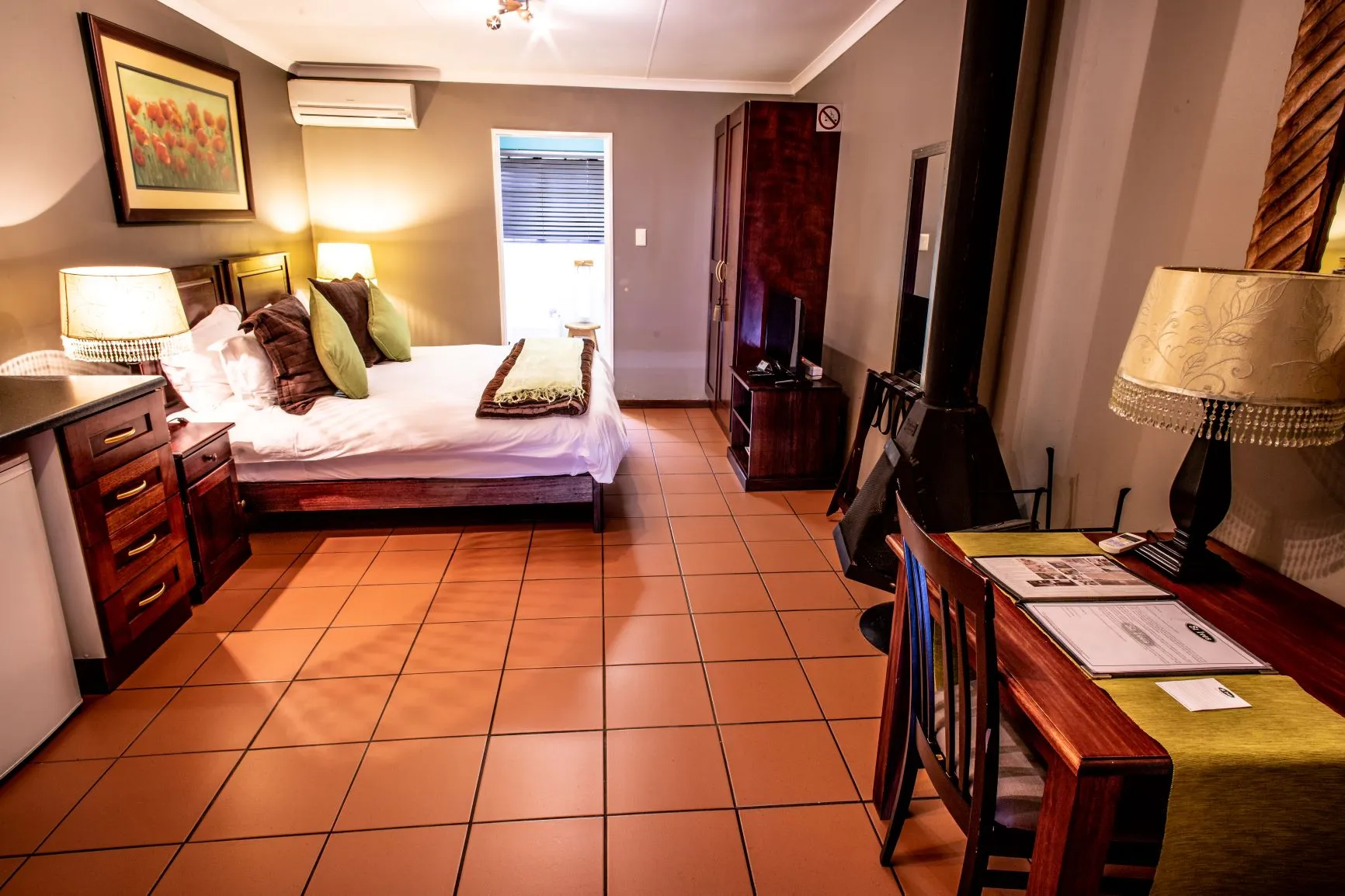 Cozy hotel room with a bed desk and tiled floor