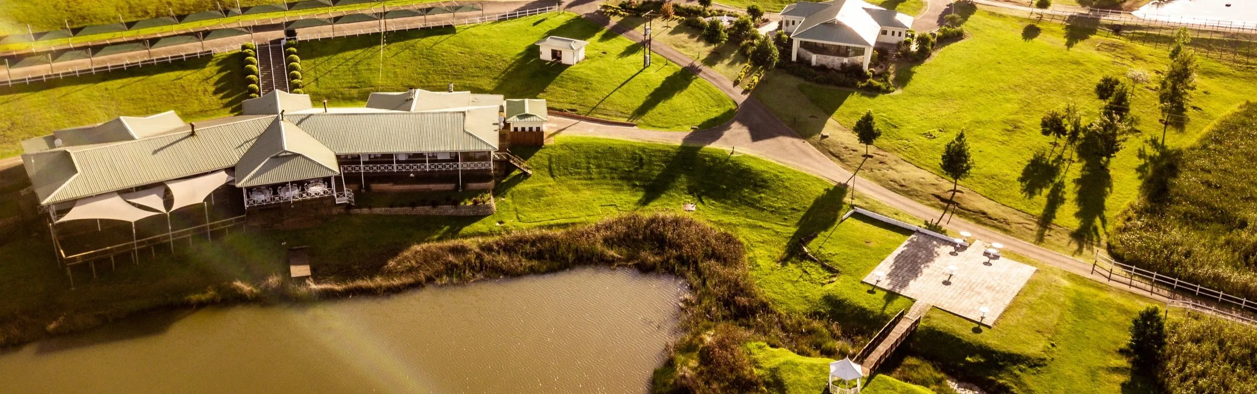 Aerial view of a resort with buildings green lawns and a pond