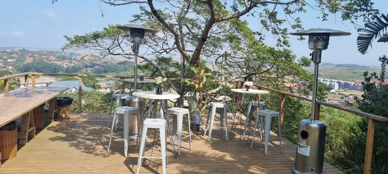 Outdoor seating area with high tables and stools on a wooden deck