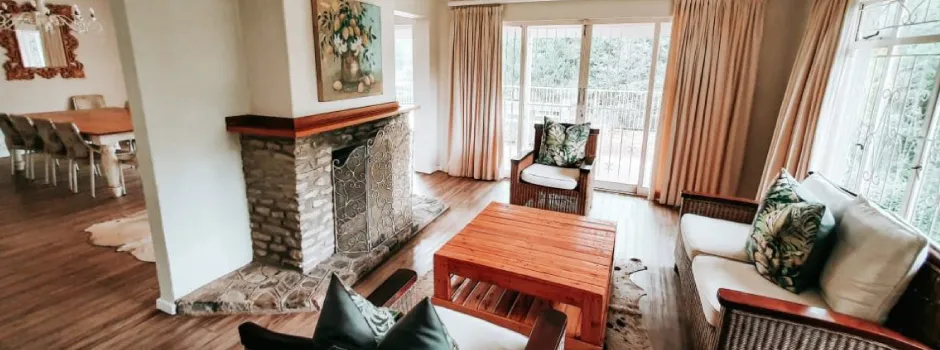 Cozy living room with fireplace wooden furniture and large windows