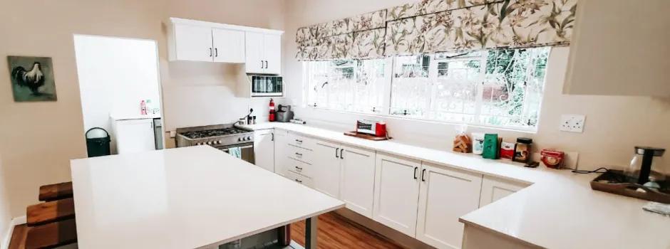 Bright kitchen with white cabinets large window and central island