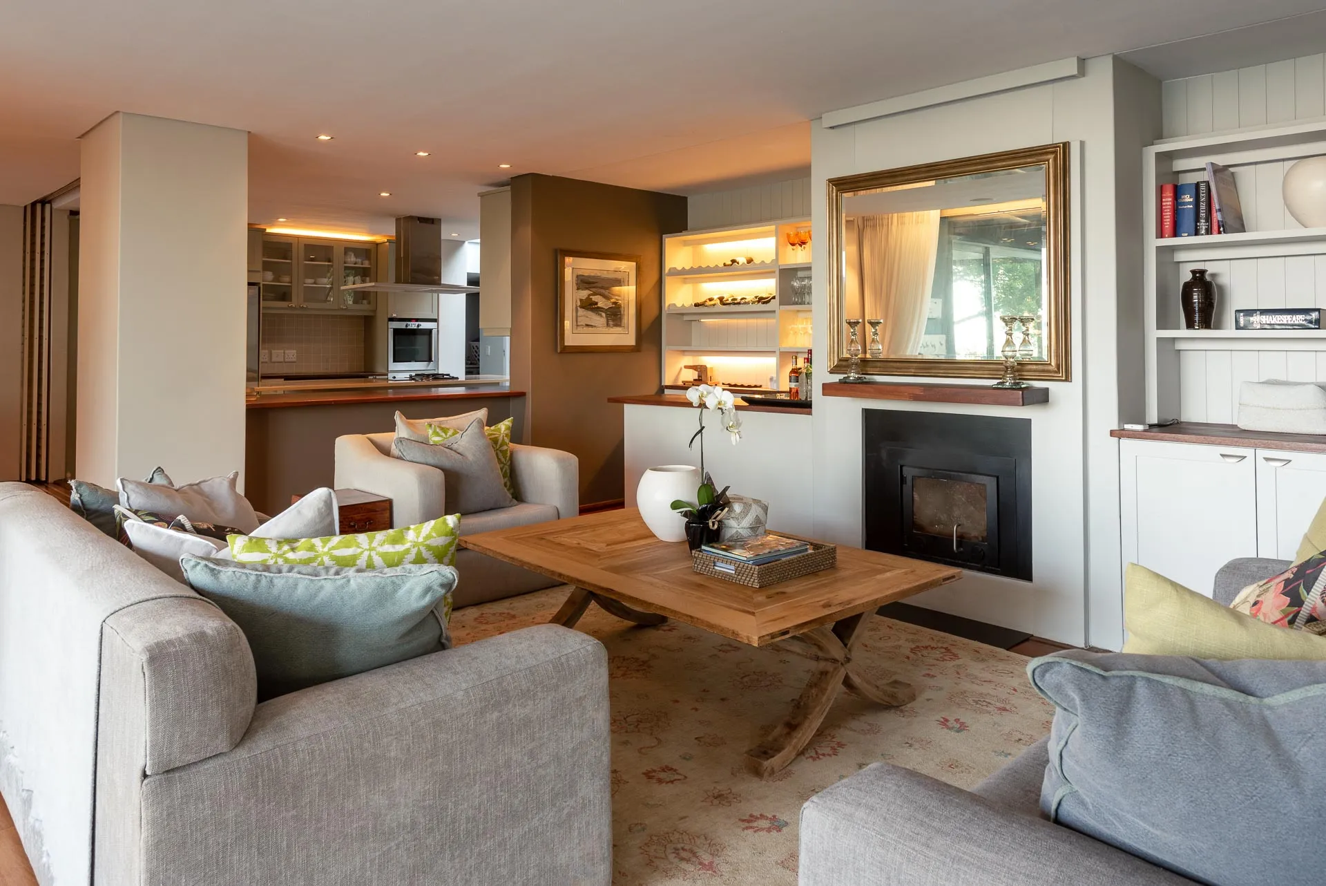 Modern living room with sofas coffee table and fireplace open to kitchen area