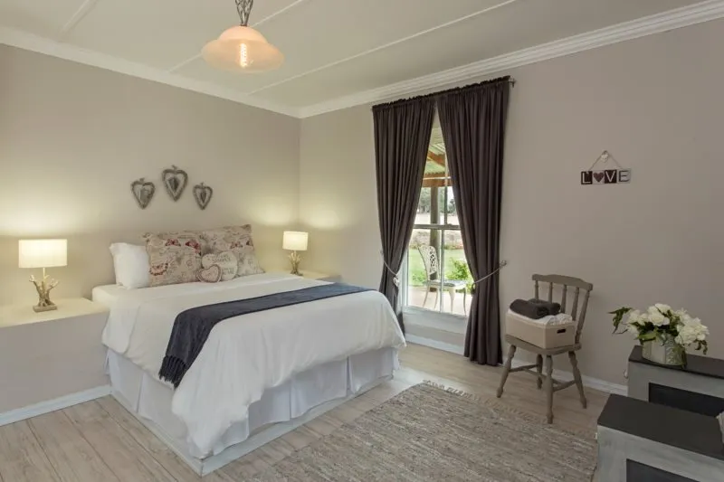 Cozy bedroom with a large bed window and wooden chair
