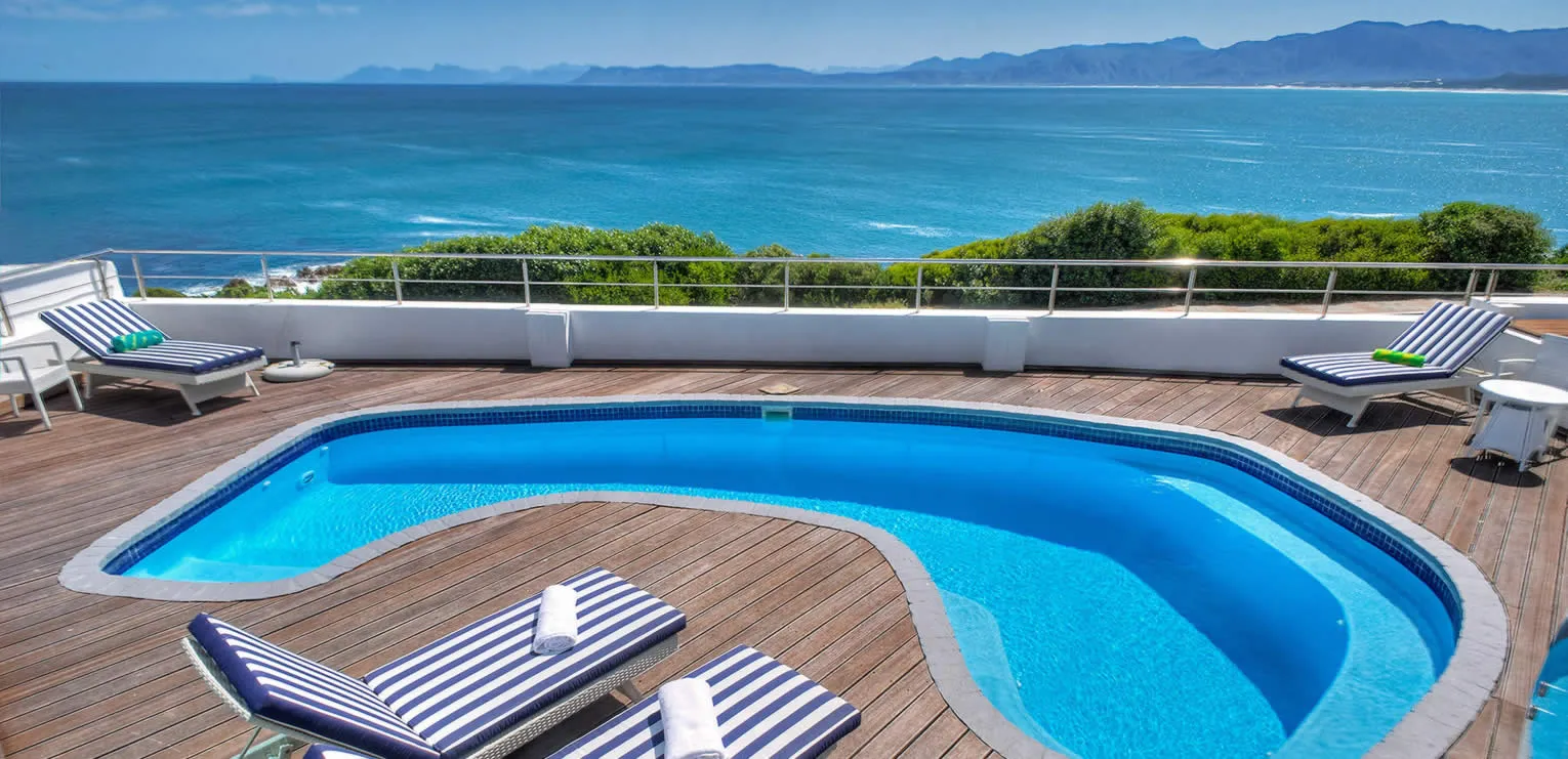 Wooden deck with pool lounge chairs and ocean view