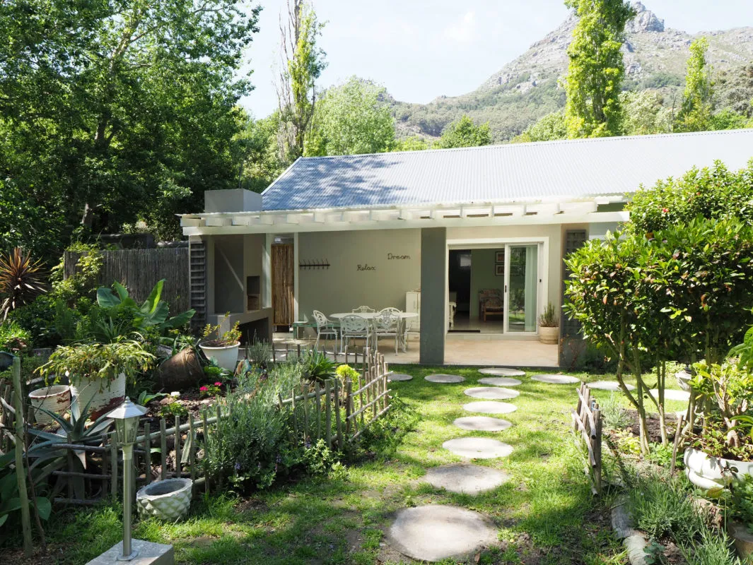 Cozy house with garden stone path and mountain view in the background