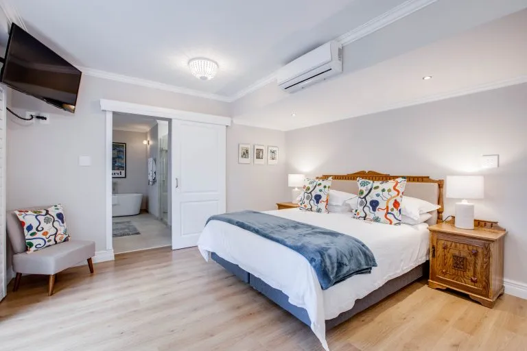 Cozy bedroom with a large bed wooden furniture and an attached bathroom