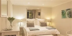 Cozy bedroom with a large bed bedside lamps and wall art