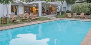 Swimming pool with lounge chairs in a backyard setting