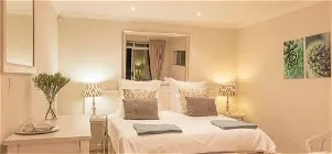 Cozy bedroom with a large bed bedside lamps and wall art