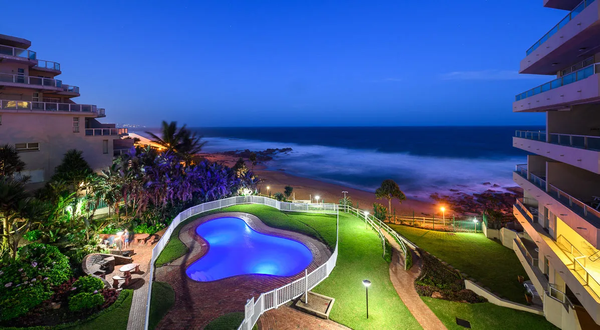 Evening view of a pool beach and ocean from a multistory building