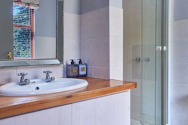 Bathroom with wooden sink counter mirror and glass shower door
