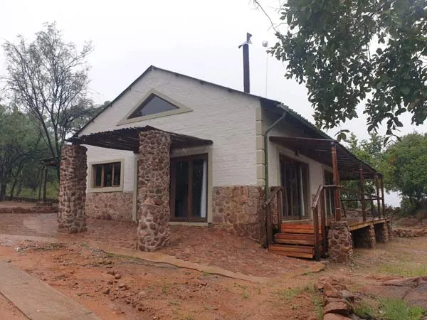 Small stone cottage with wooden porch in a natural setting