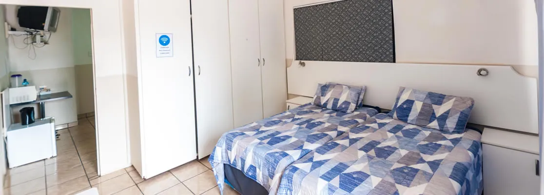 Bedroom with double bed patterned bedding and builtin wardrobes