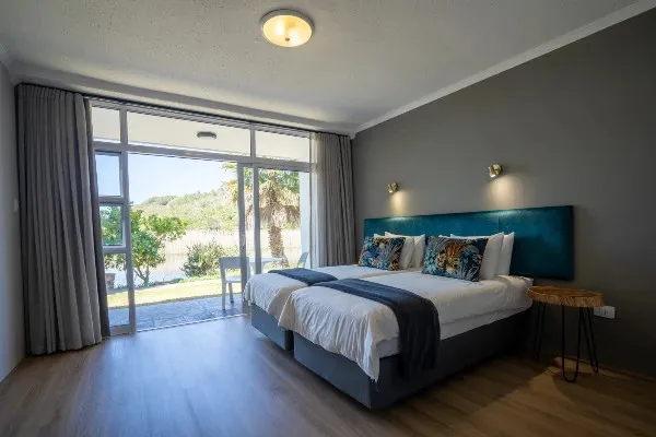 Modern bedroom with two beds large window and garden view