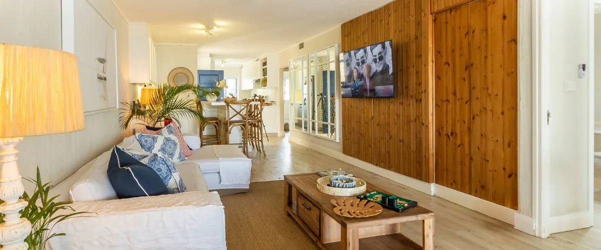 Bright living room with white sofa wooden TV wall and coastal decor