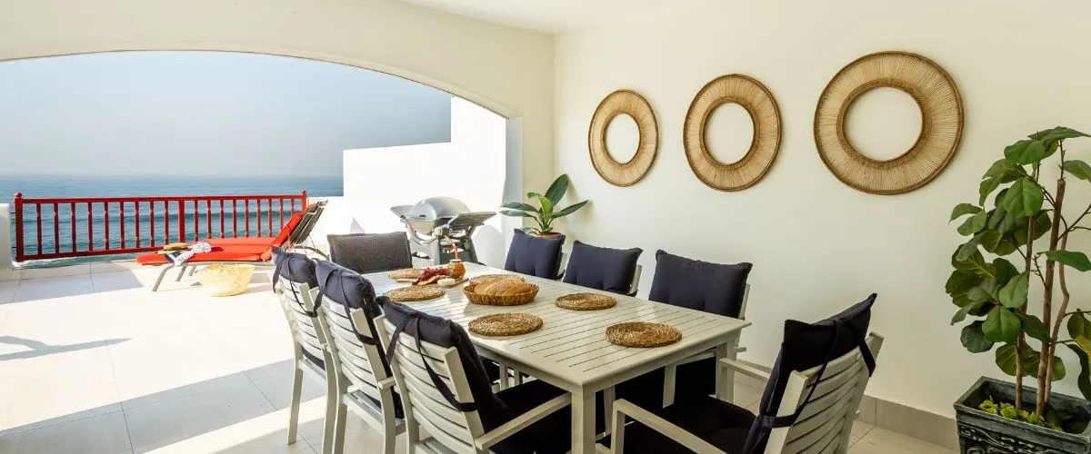 Outdoor dining area with table chairs and ocean view on a patio