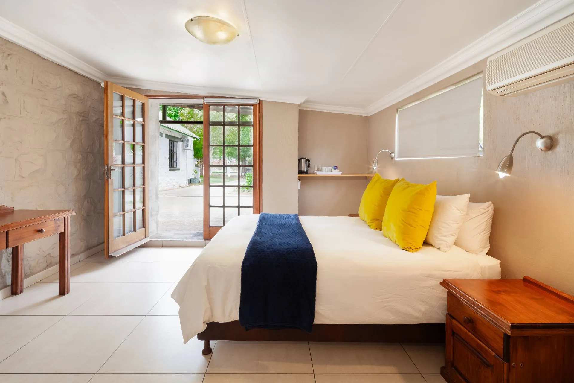 Bedroom with a bed wooden furniture and an open door to an outdoor area