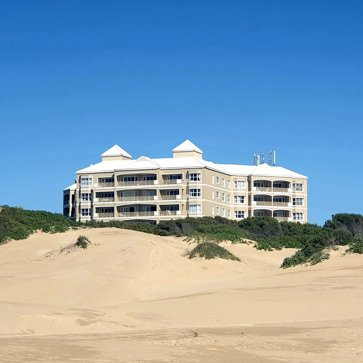 Building on sand dunes with clear blue sky in the background
