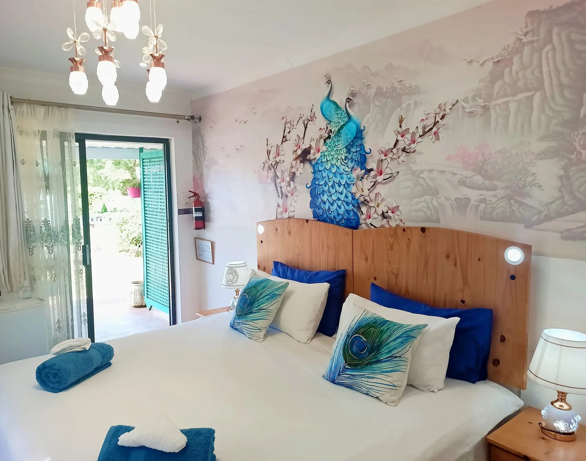 Bedroom with peacockthemed decor large bed and floral wallpaper