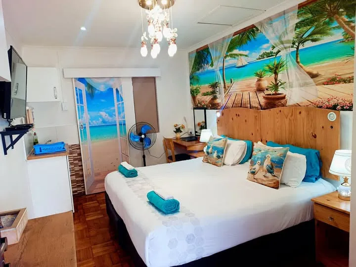 Cozy bedroom with beachthemed decor wooden furniture and a ceiling fan