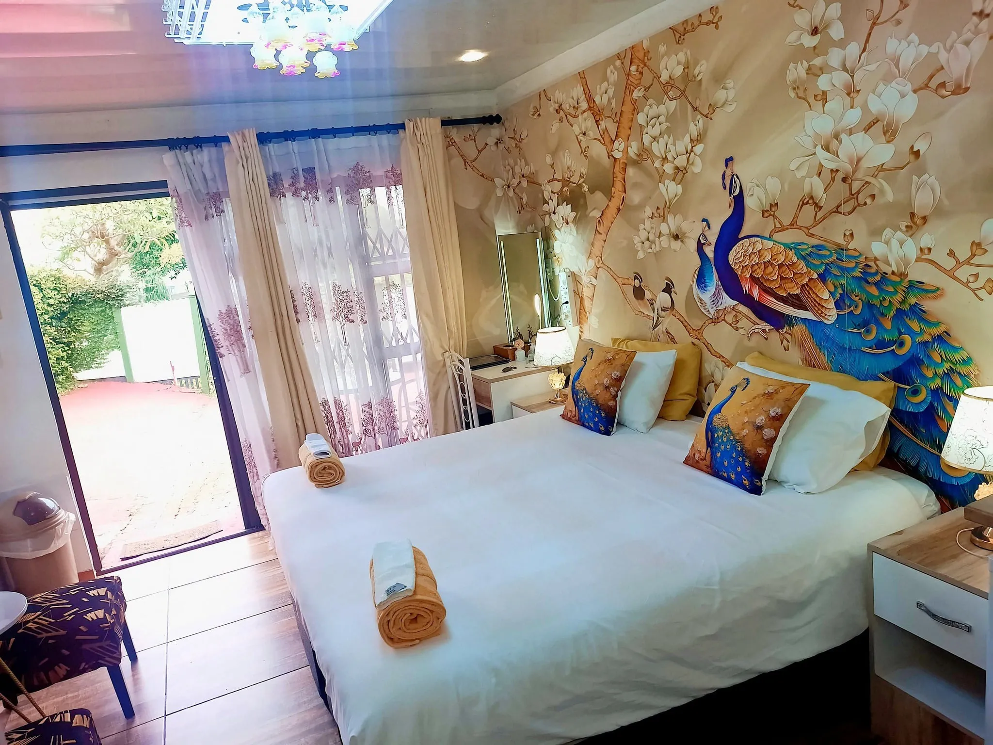 Bedroom with peacockthemed decor large bed and open patio door