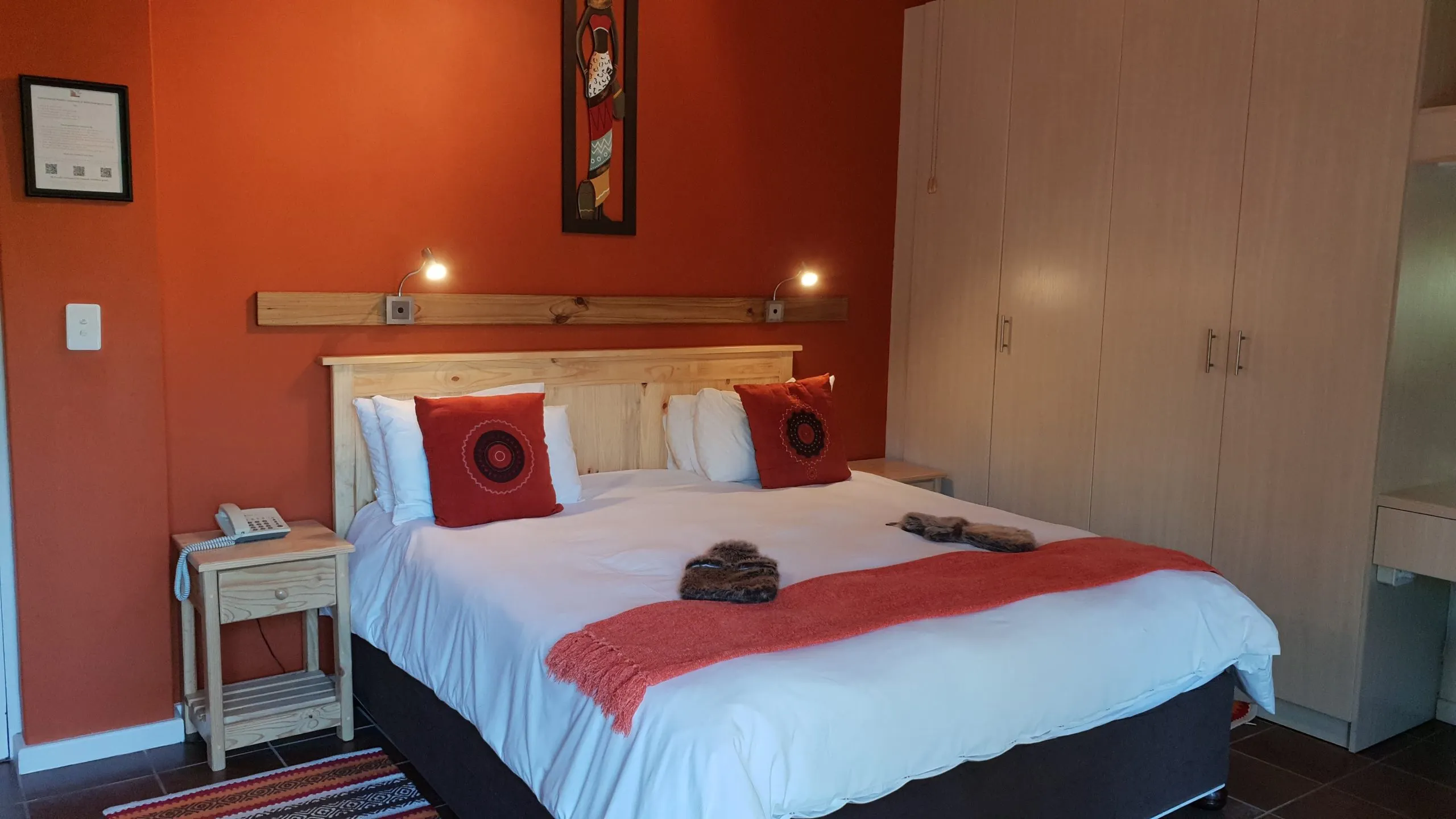 Cozy bedroom with a large bed red decor and wooden furniture