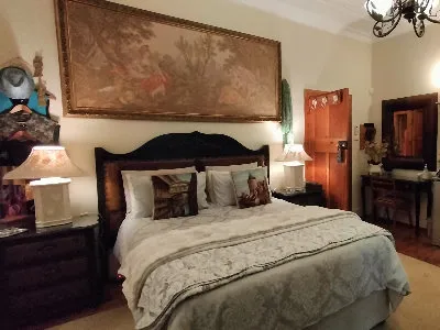 Cozy bedroom with large bed artwork above and wooden furniture