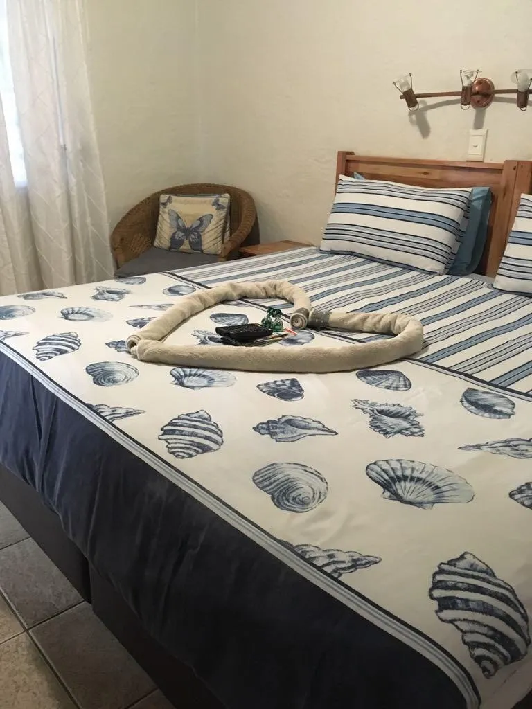 Bedroom with a bed decorated with towels shaped like a heart and seashell bedding