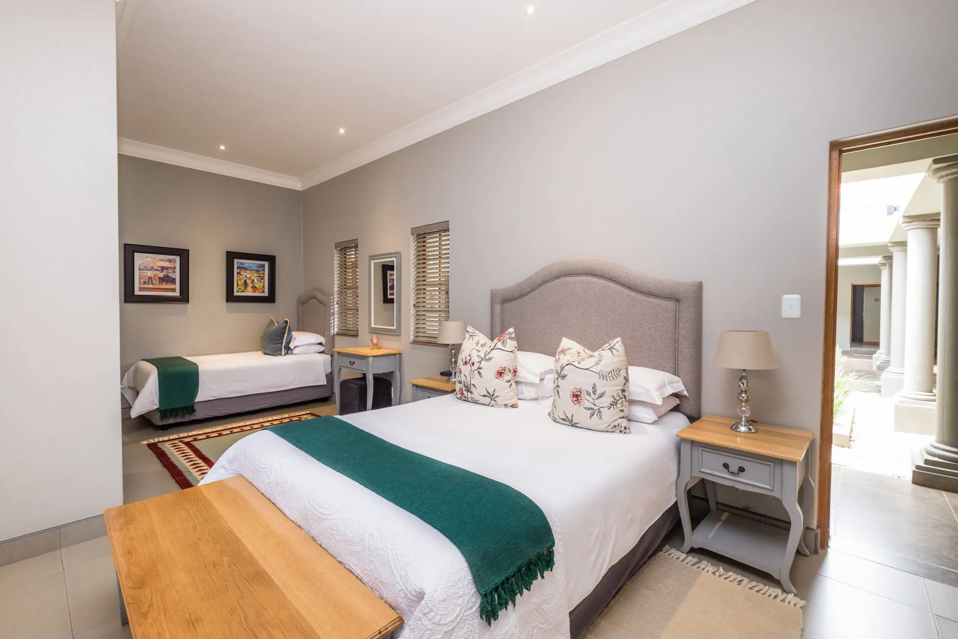Bedroom with two beds wooden furniture and wall art in a modern setting