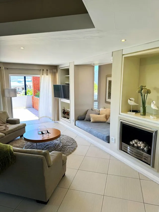 Cozy living room with fireplace TV and balcony view