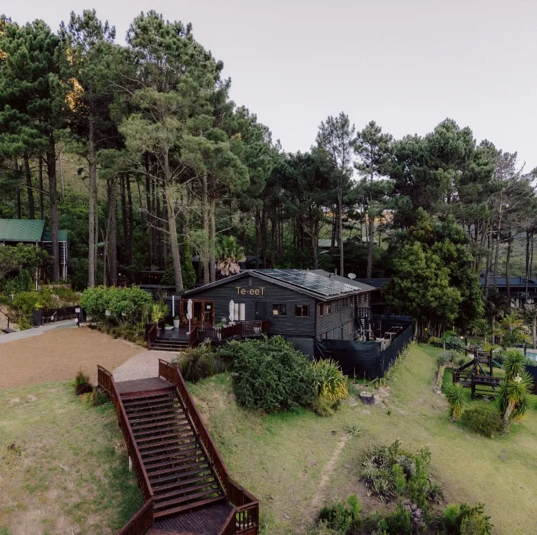 Wooden cabin in a forest with a staircase leading up to it