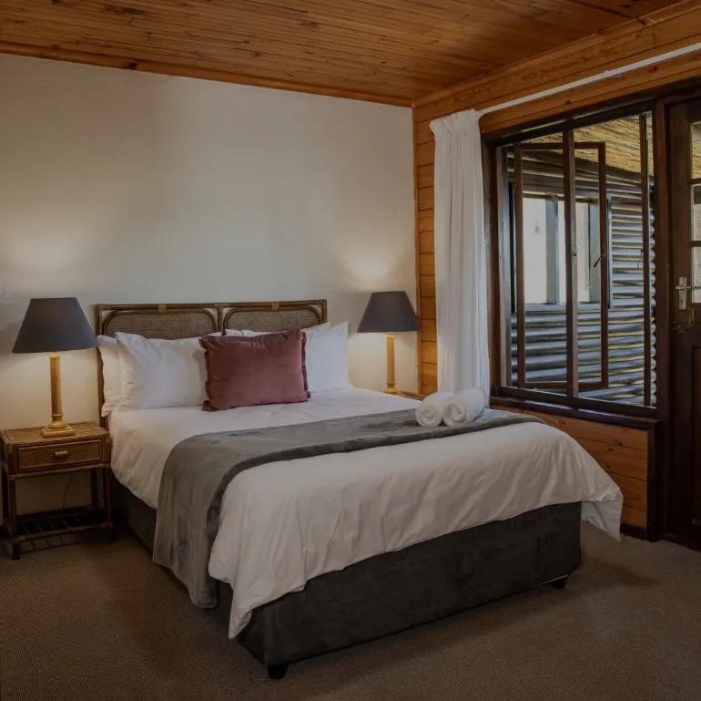 Cozy bedroom with a large bed wooden walls and large windows