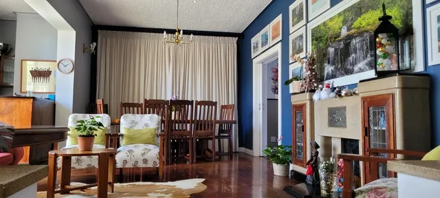 Cozy living room with wooden furniture plants and naturethemed wall art