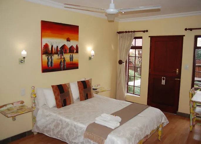 Cozy bedroom with a bed artwork and garden view through a glass door