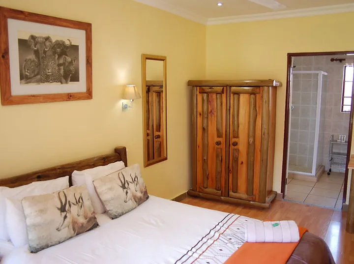 Bedroom with wooden furniture animal print pillows and an attached bathroom