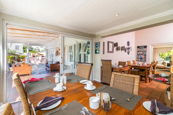 Dining area with wooden table wicker chairs and open view to outdoor patio