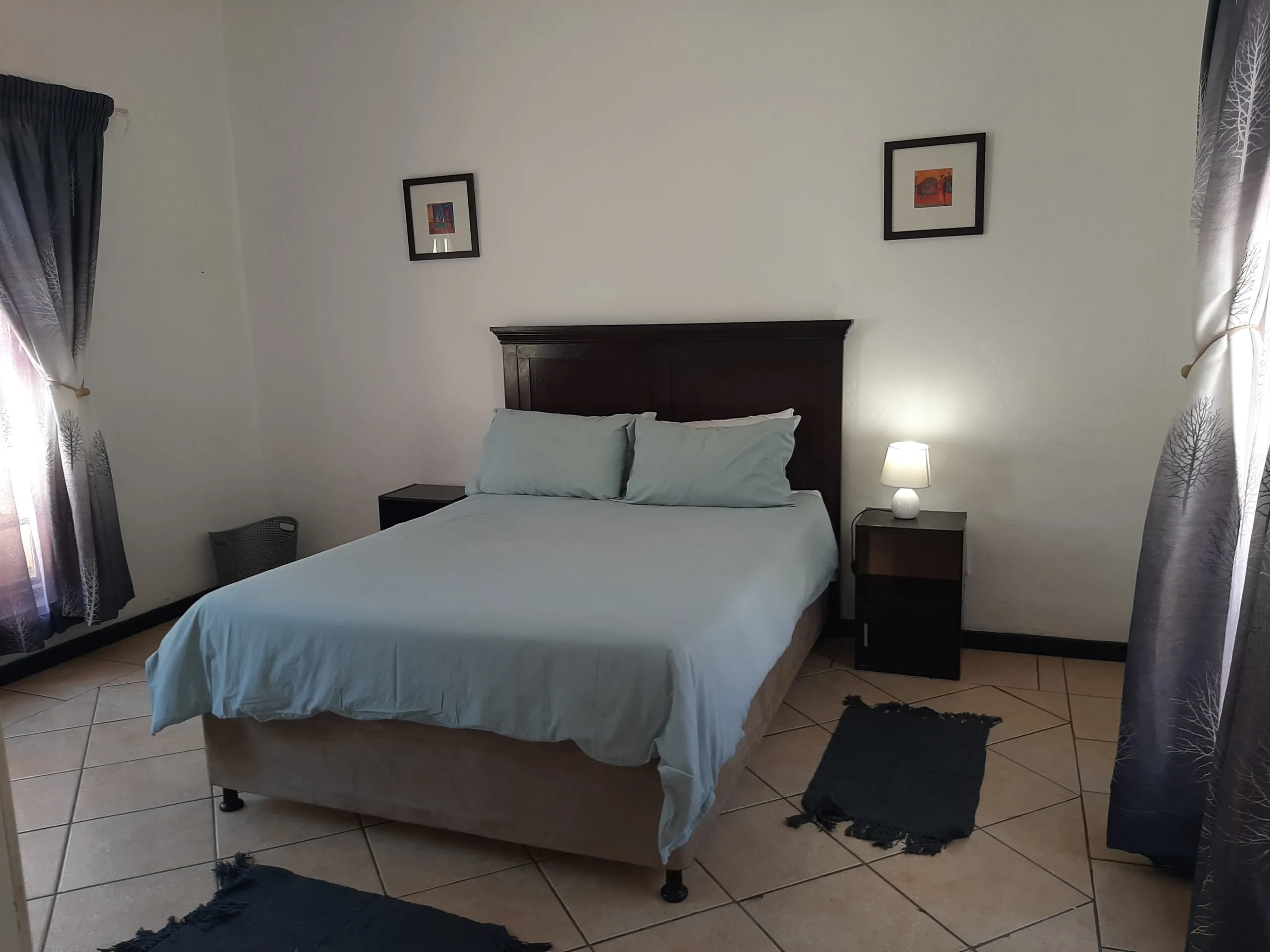 Bedroom with a double bed bedside tables and tiled floor